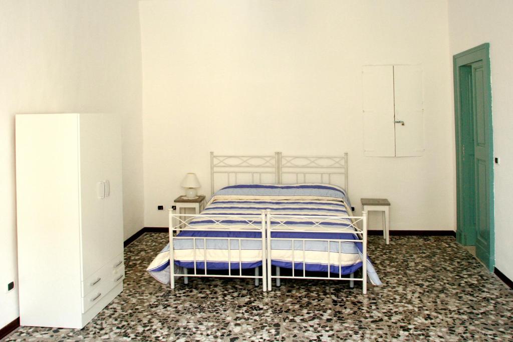卡萨拉诺Palazzo Gallo的一间白色卧室,配有一张床和两张桌子