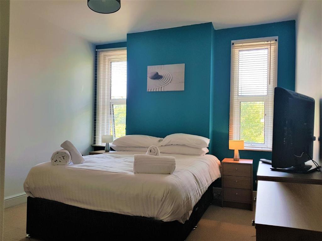 史云顿巴斯路公寓的一间卧室设有一张蓝色墙壁的大床