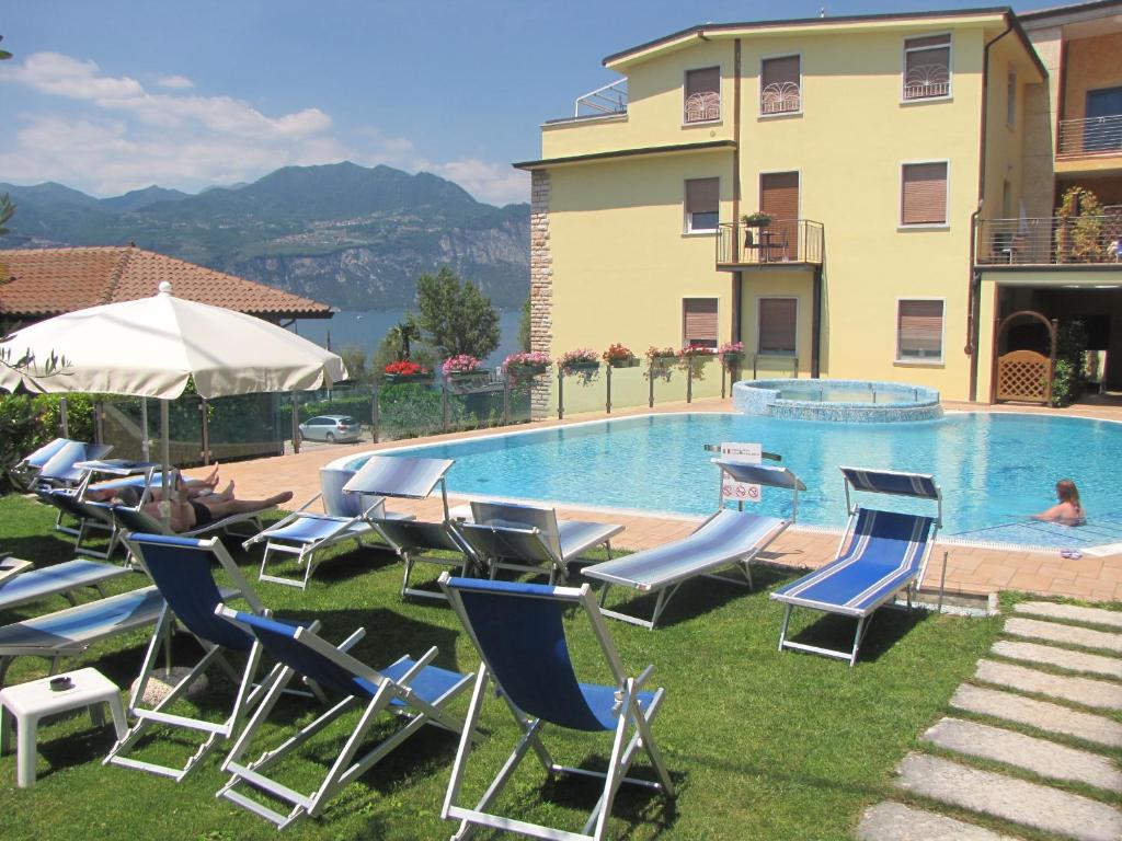 布雷佐内加尔达Hotel Garni Rosmari的一组草坪椅和一个游泳池