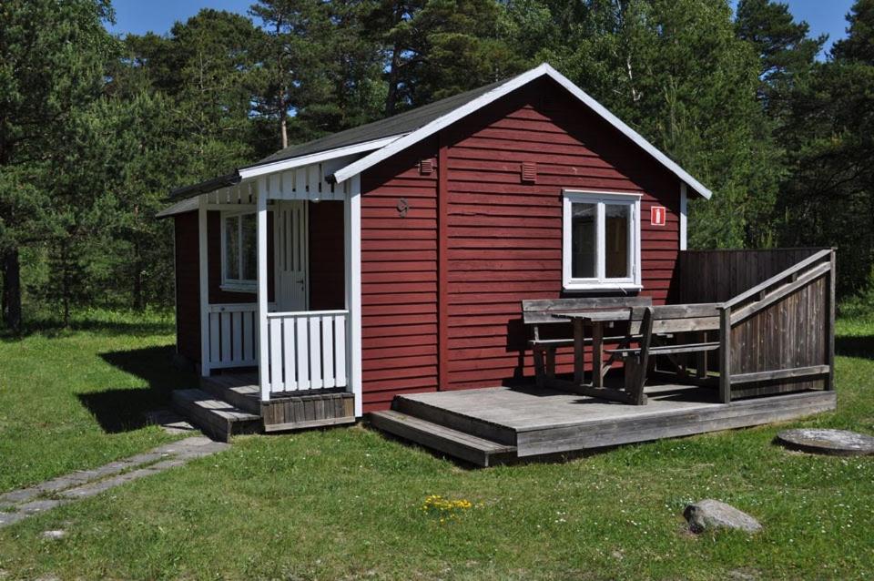 KlintehamnSnäckan的一个小红色棚子,设有门廊和甲板