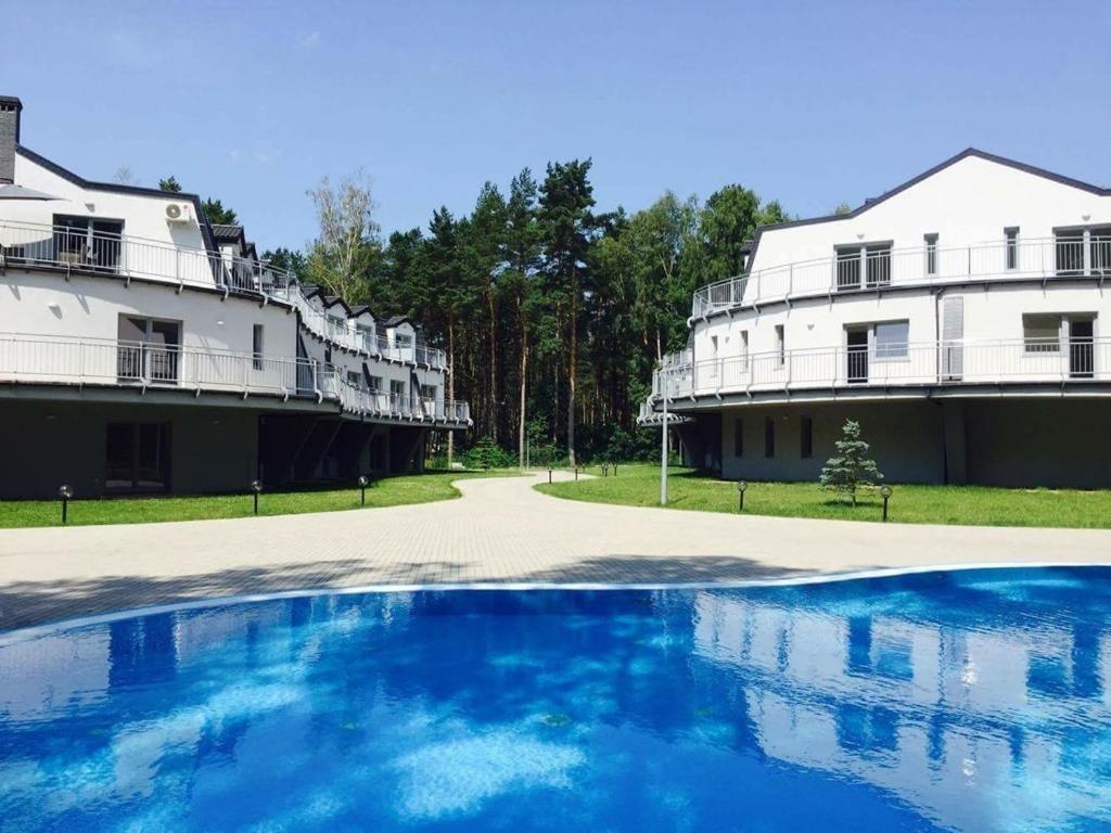 波别罗沃Apartamenty Silence Blue Baltic的一座白色的大建筑,前面设有一个游泳池