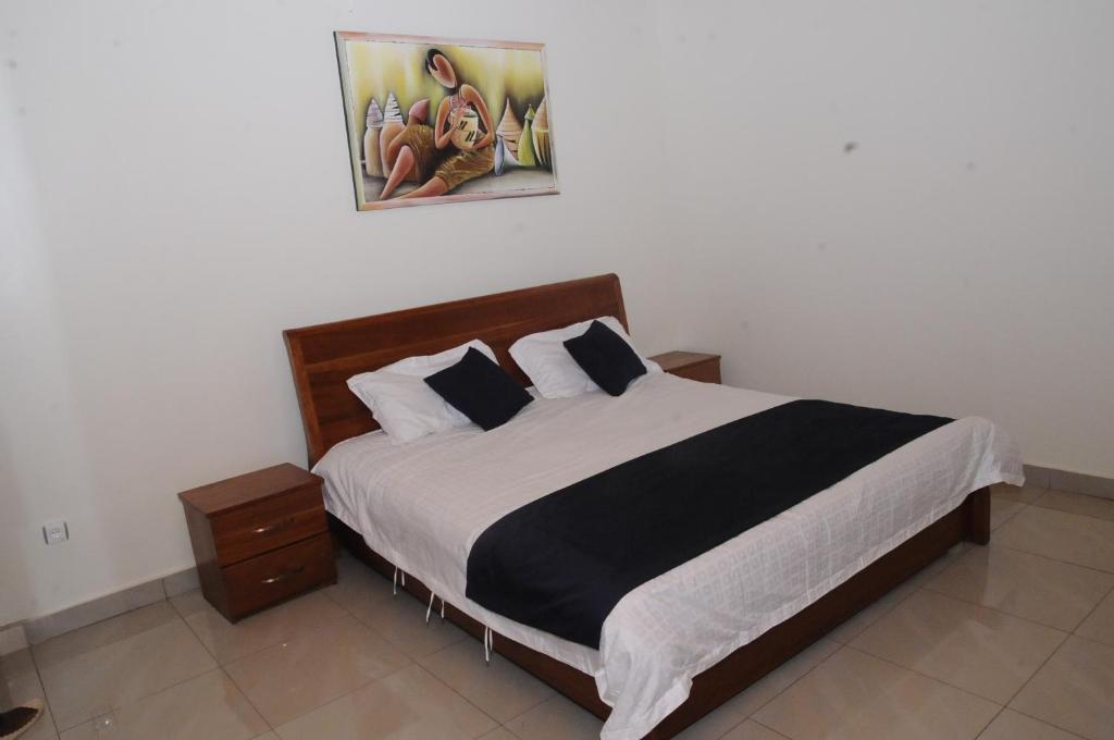 基加利Keva Guest House的一间卧室配有一张大床,铺有黑白床单。
