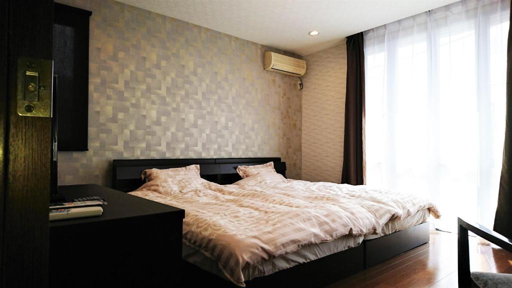 京都京都古都音旅馆的一间卧室配有一张床、一张书桌和一个窗户。