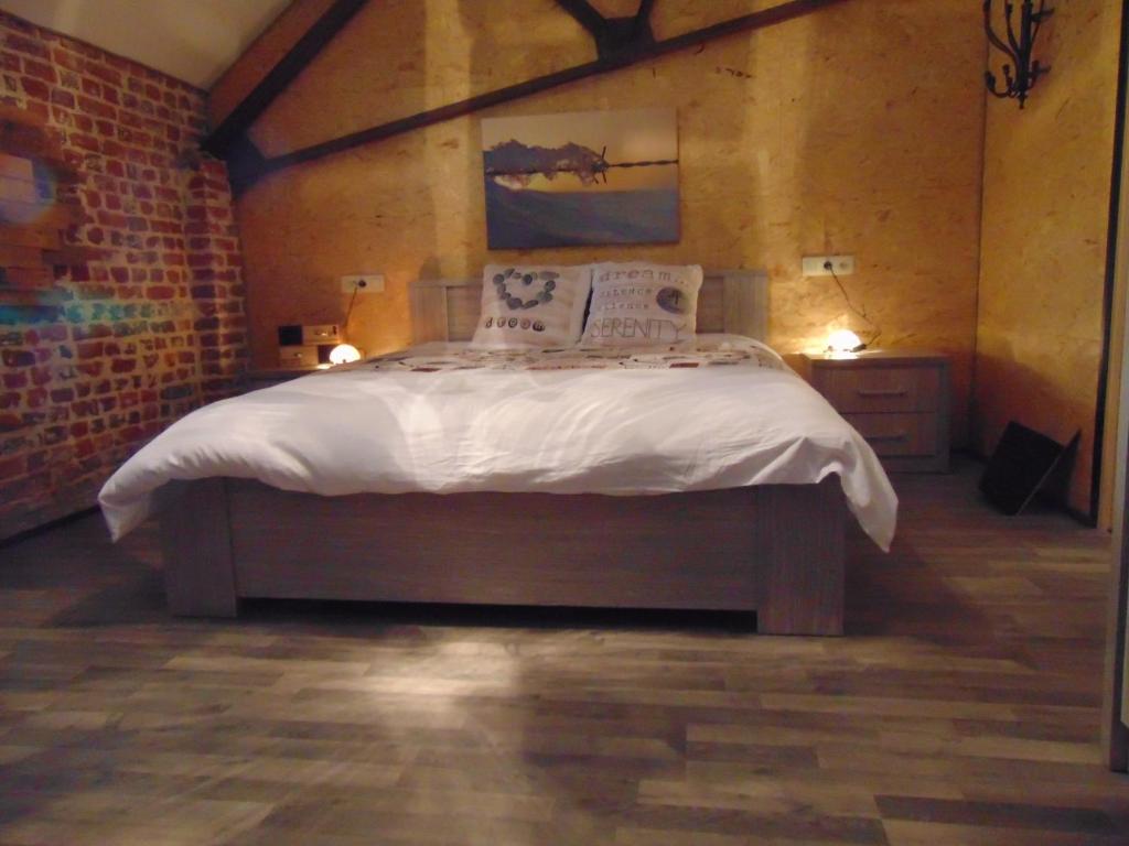 GeerLomalienne的卧室配有一张带白色床单和枕头的大床。