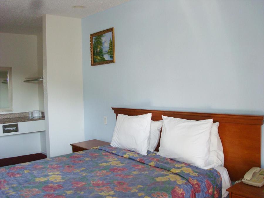 长滩苏格兰汽车旅馆的一间酒店客房,配有一张床和一部电话