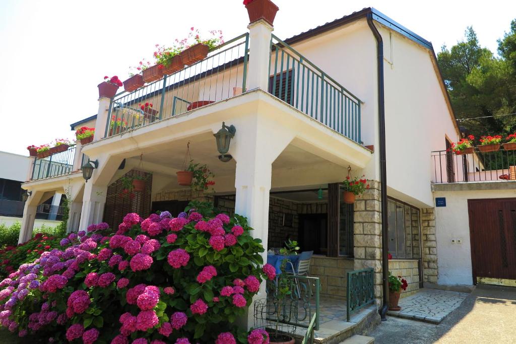 罗维尼Villa Matohanca的带阳台的房子和一束鲜花