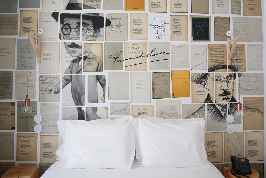科英布拉萨派恩提亚精品酒店的一间卧室,墙上挂着海报