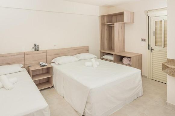 约恩维利多伊什酒店的白色卧室配有白色的大床和架子