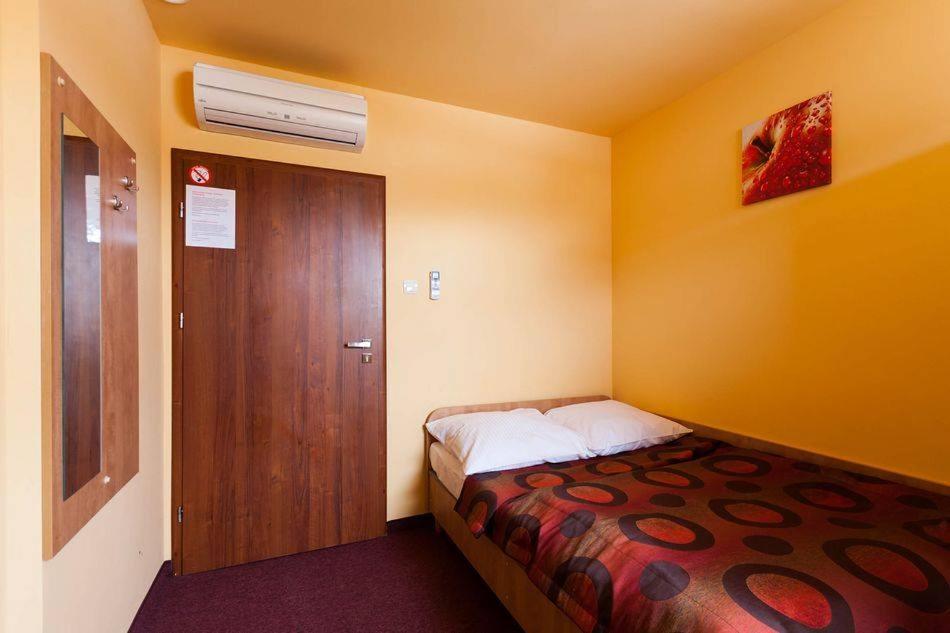 库特诺Hotel Paola的一间小卧室,配有一张床和一扇木门