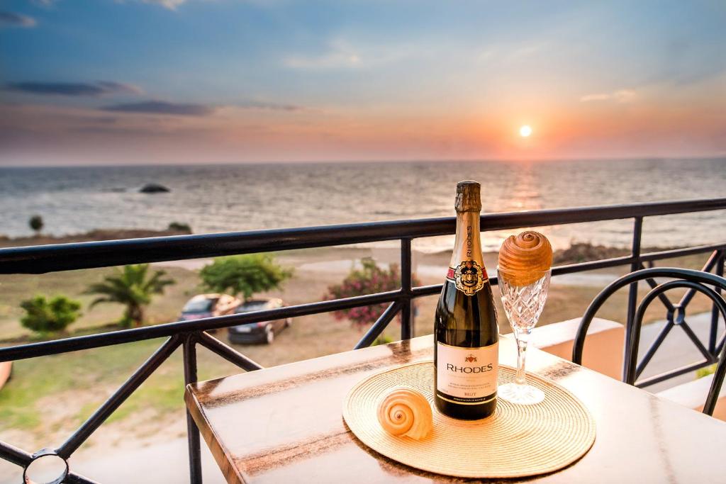 米提卡斯法罗斯公寓酒店的一瓶葡萄酒和一杯海滩上的茶几