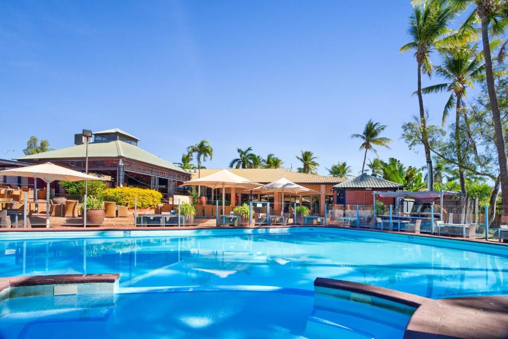 卡拉萨卡拉萨国际大酒店的度假村内带椅子和遮阳伞的大型游泳池