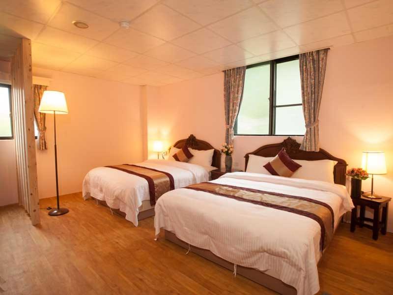 礁溪理想温泉饭店 的酒店客房设有两张床和窗户。