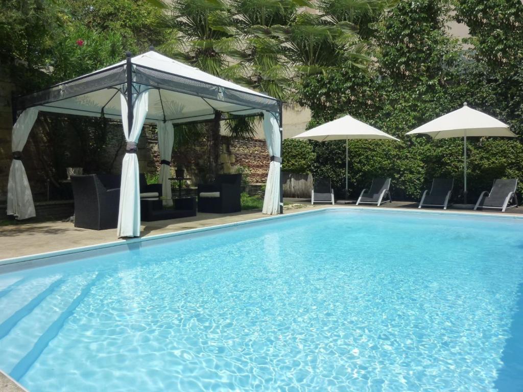 贝尔热拉克法兰西酒店的一个带天蓬、椅子和遮阳伞的游泳池