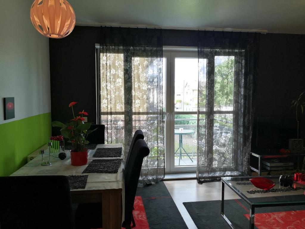海德堡海德堡夏洛特公寓的客厅设有书桌和大窗户