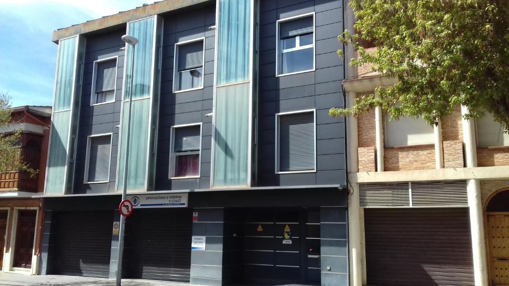 阿尔卡扎德三涓Apartamentos Turísticos Los Ángeles的街道上带玻璃窗的公寓大楼
