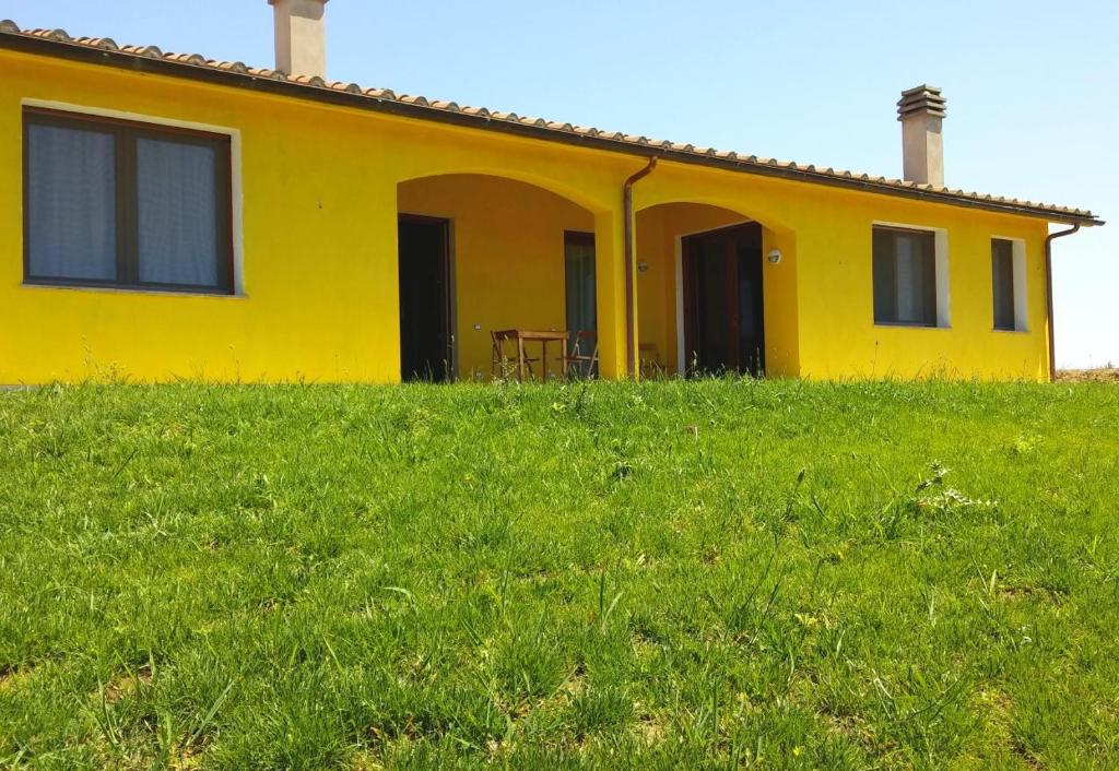 卡帕尔比奥Il Chiosco Giallo的郁郁葱葱的绿色田野顶部的黄色房子