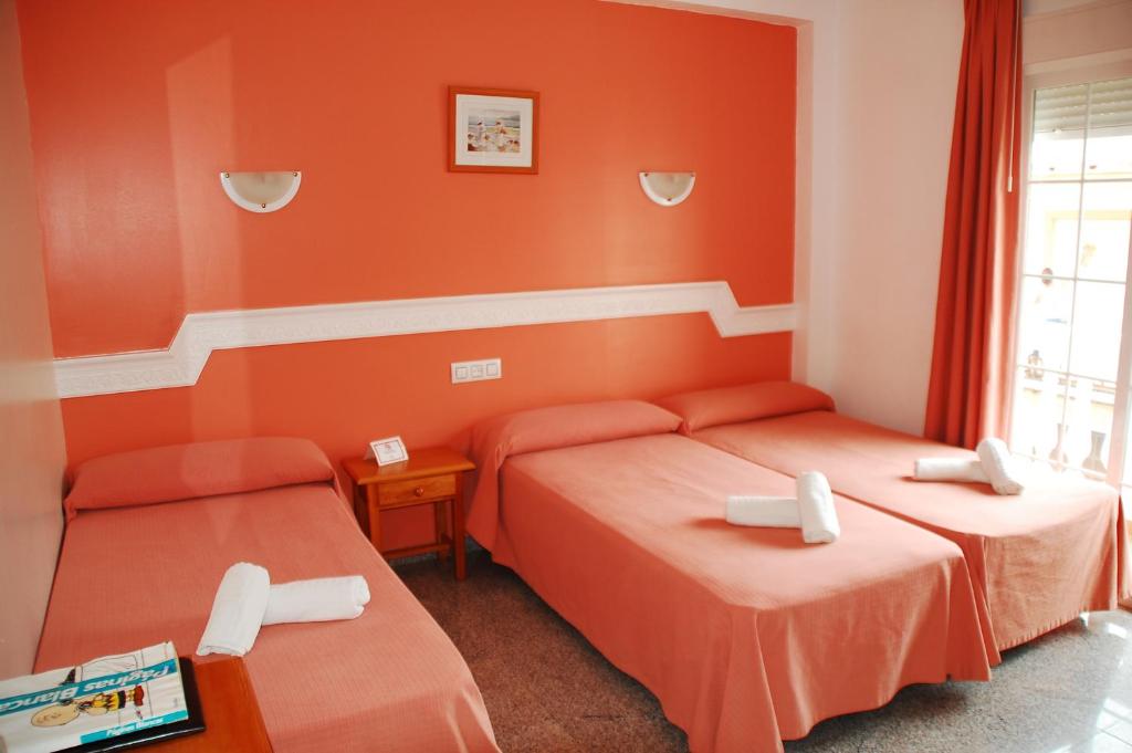 萨各夫雷纳玛丽特尔酒店的橙色墙壁客房的两张床