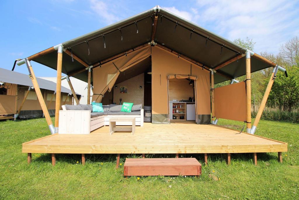泽沃德Camping Marina Eemhof的一个带甲板的大帐篷