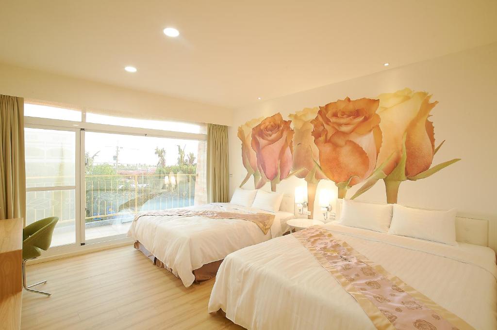 东港大鹏湾瞭望台Top Bay B&B的一间卧室配有两张床和鲜花壁画