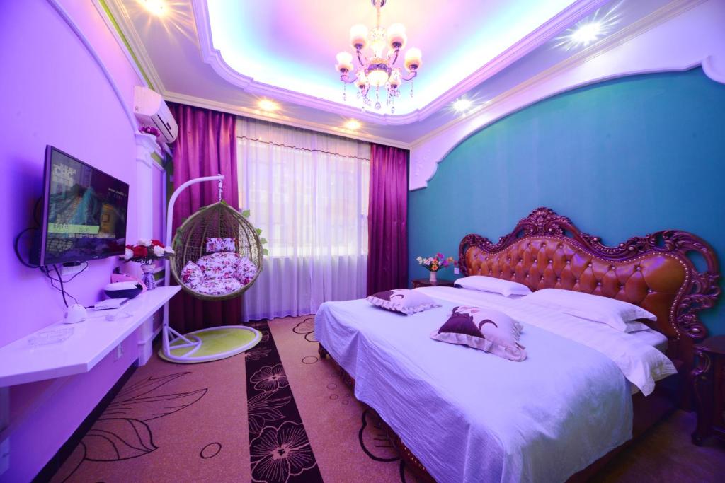 峨眉山峨眉山月亮湾酒店的一间卧室设有两张床,拥有粉红色和紫色的墙壁