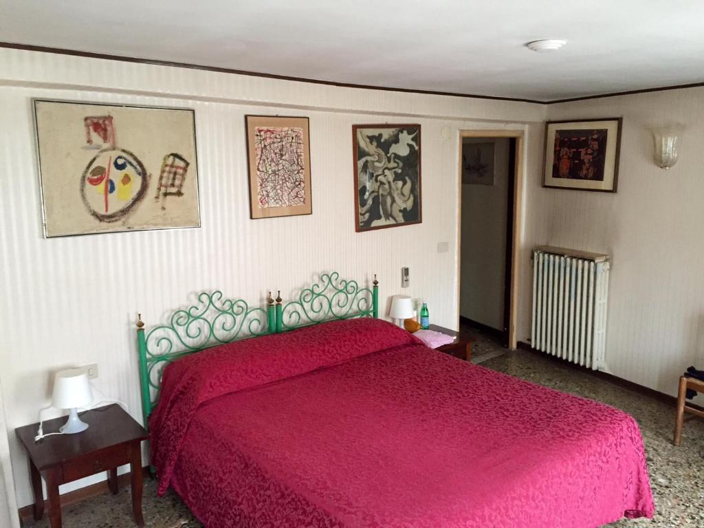 威尼斯安提卡罗坎达蒙提酒店的一间卧室配有一张红色床罩的床