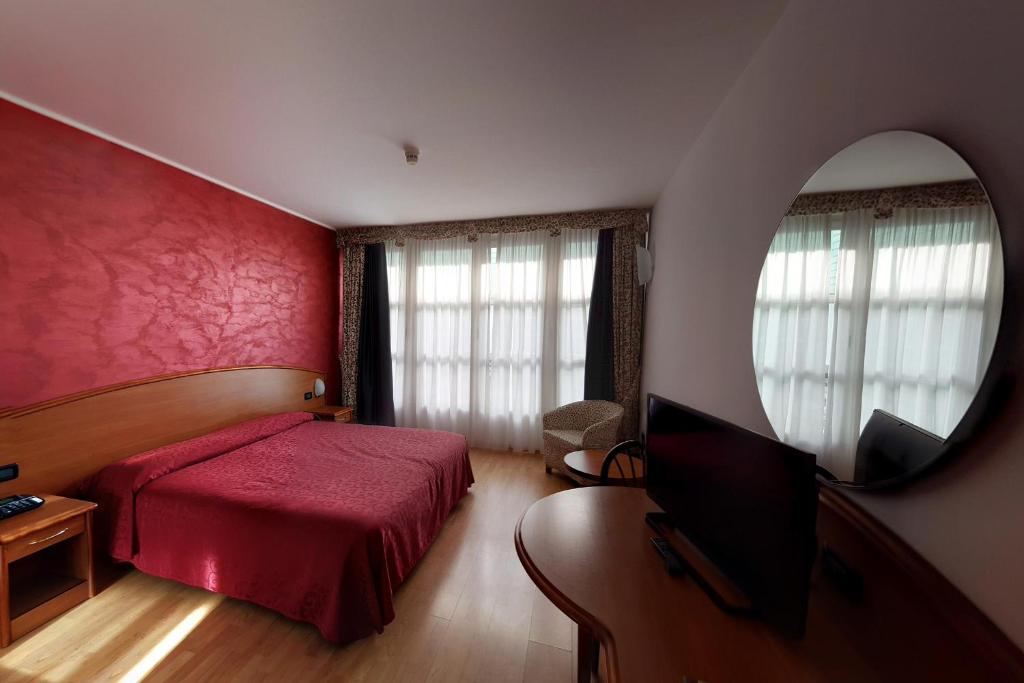 比耶拉欧罗巴酒店 的一间卧室配有一张床、一台电视和一面镜子