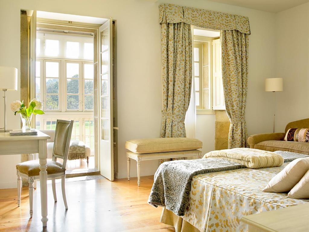 列尔加内斯Posada Villa Esperanza的一间卧室设有两张床、一张桌子和一个窗口。