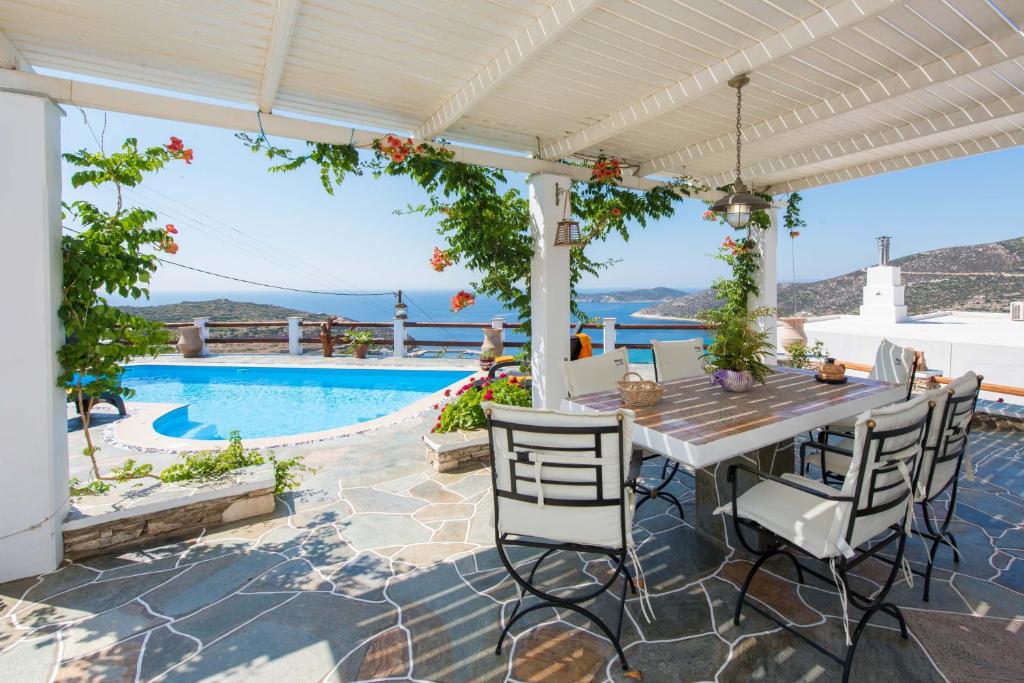 普拉提伊亚洛斯西弗诺斯海洋别墅的一个带桌椅的庭院和一个游泳池
