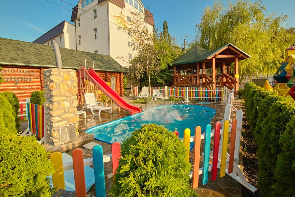 克列梅涅茨Hotel Panorama的后院的游泳池,带滑梯和游乐场