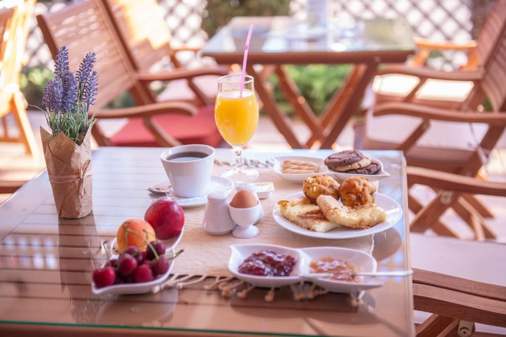 帕拉利亚卡泰里尼斯Hotel Vizantio的一张桌子,上面放着一盘早餐食品和饮料