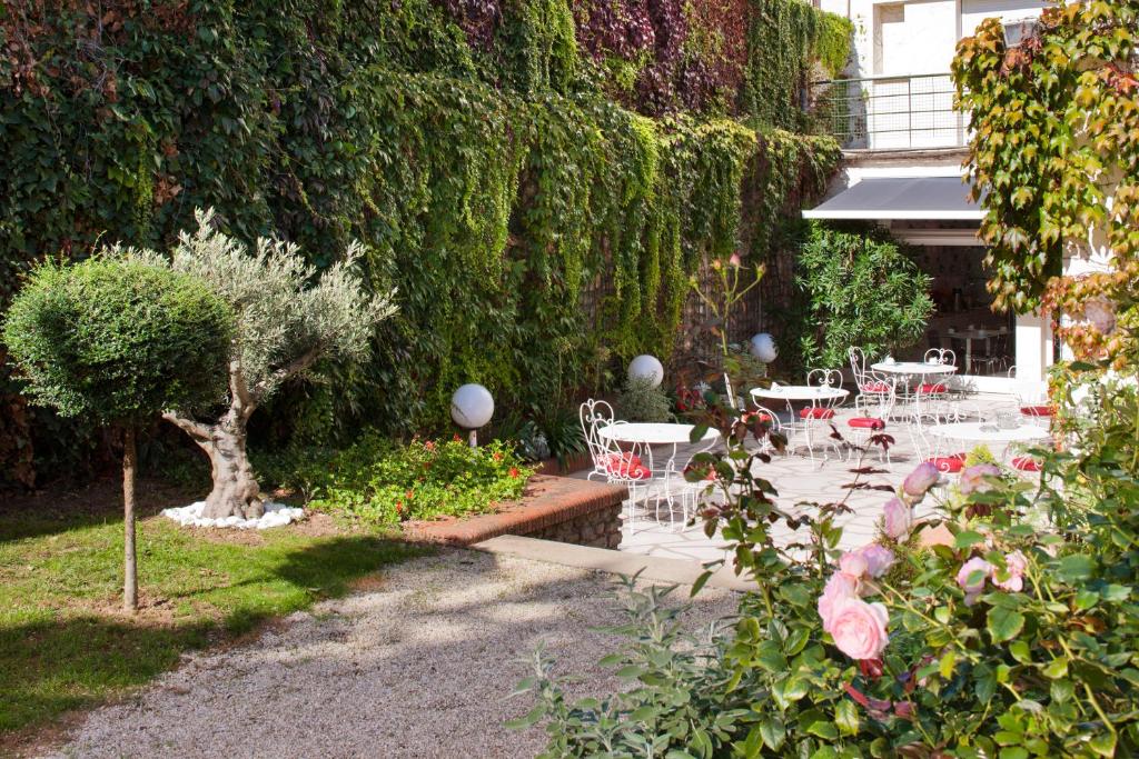 尼奥尔Grand Hôtel Niort Centre的花园设有桌椅和树 ⁇ 