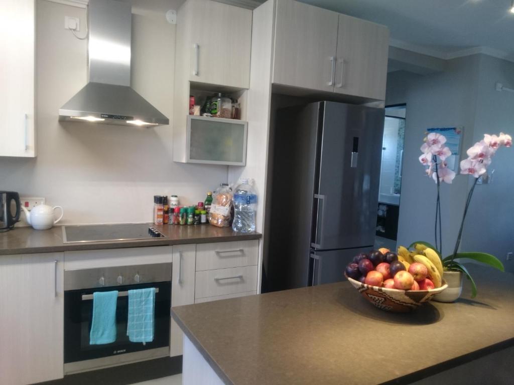 哈博罗内Lifestyle Apartments的厨房在柜台上放一碗水果