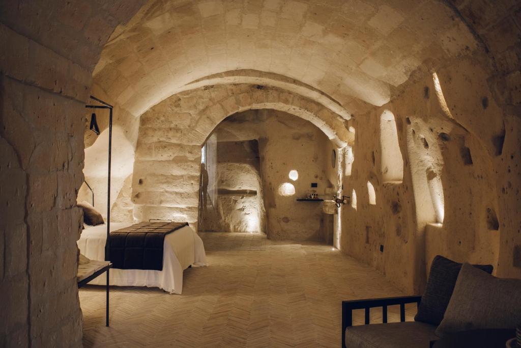 马泰拉帕拉索托酒庄民宿的石洞内一间卧室,配有一张床铺