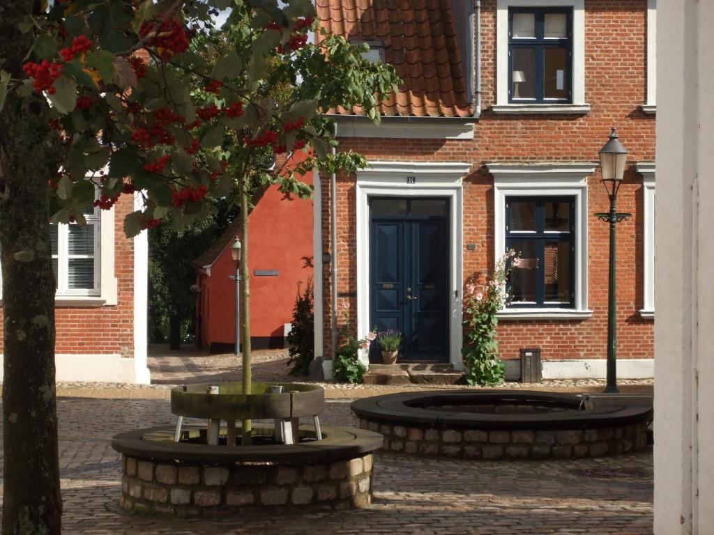 维堡Nattely I Viborg By的一座有蓝色门和一棵树的建筑
