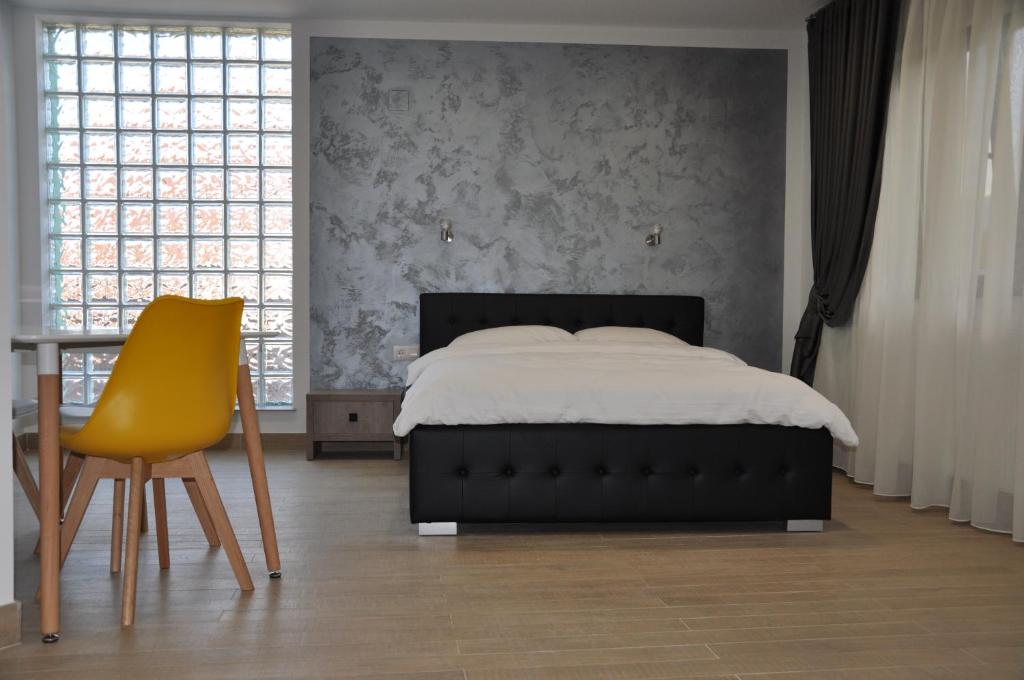 克利默内什蒂耶斯公寓的一间卧室配有一张床、一张桌子和一张黄椅