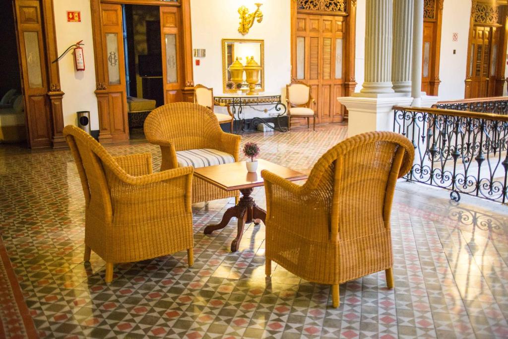 梅里达艾尔格兰酒店的客厅配有两把椅子和一张桌子