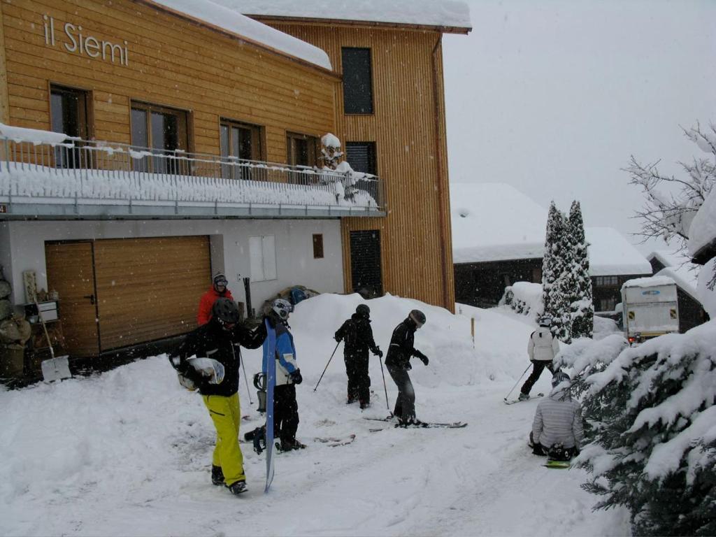 Luven西埃米之家住宿加早餐旅馆的一群人站在滑雪小屋外的雪地里