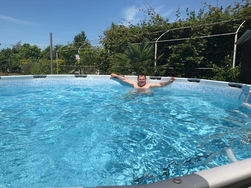 古达乌塔Vse Dlya Vas Guest House的一个人在游泳池里
