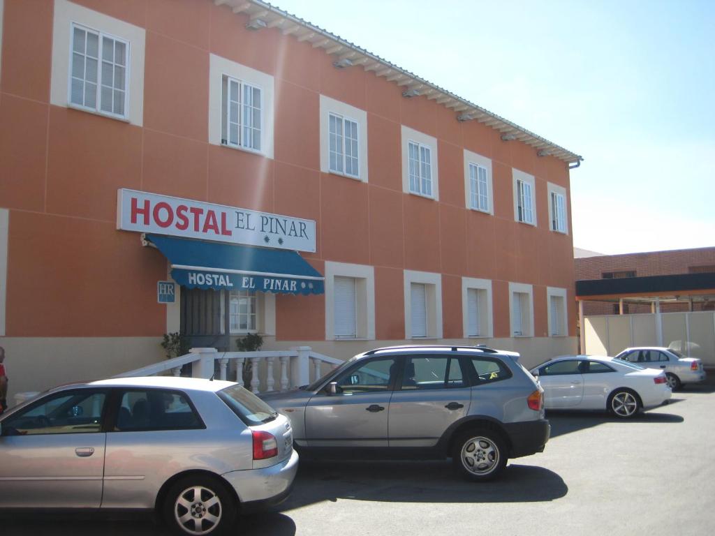 阿维拉萨尔瓦多德尔皮纳尔旅馆的停在大楼前的一组汽车