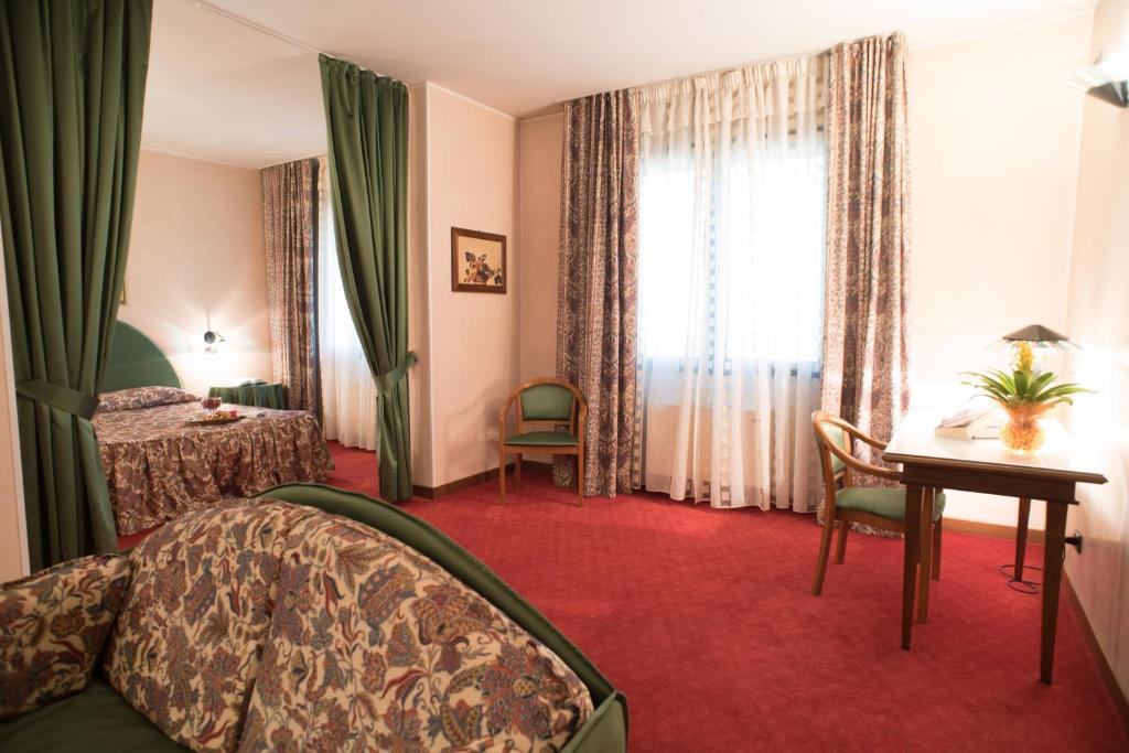 Taglio di Po特萨林酒店的配有一张床、一张书桌和一扇窗户的酒店客房