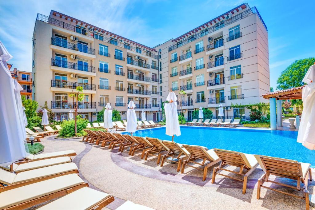 阳光海滩Dawn Park Complex的酒店游泳池设有躺椅和遮阳伞