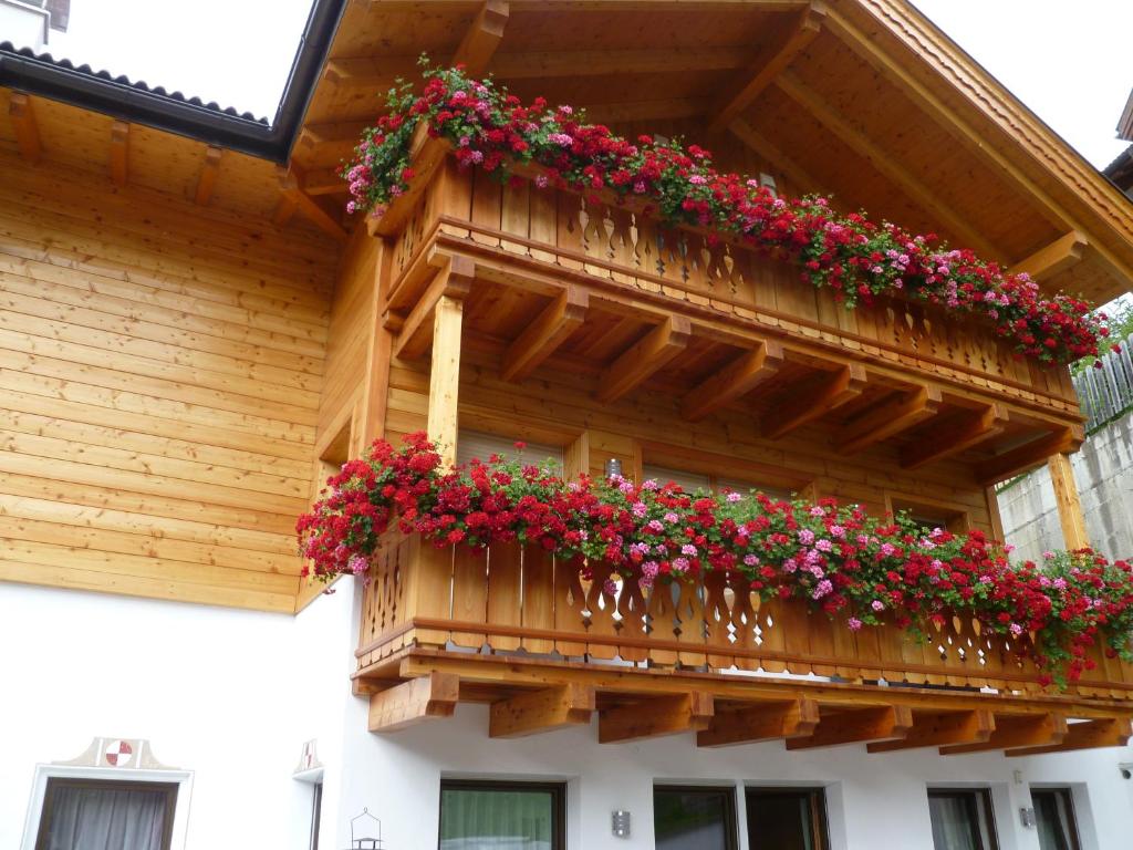 圣克里斯蒂娜Apartment Albert的木质建筑中带鲜花的阳台