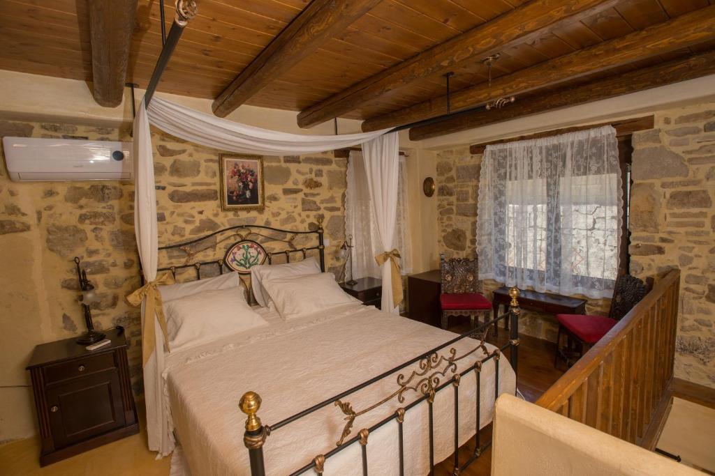 皮特斯迪亚kritikies1的一间卧室配有一张床、一张桌子和一个窗户。