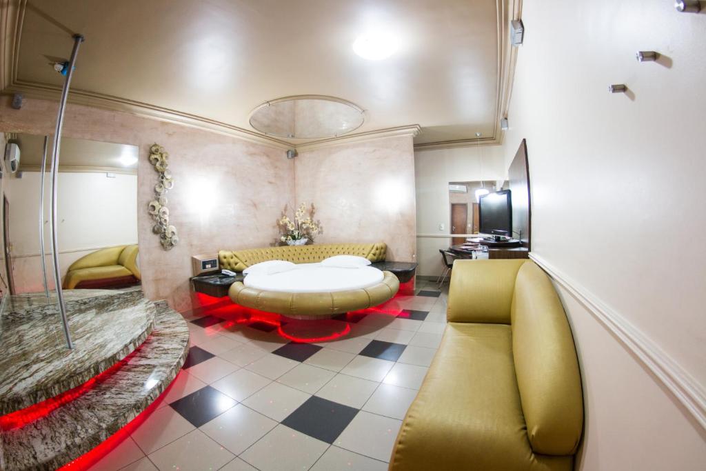 福塔莱萨Shanadu Motel (Adults Only)的客厅配有黄色的沙发和桌子