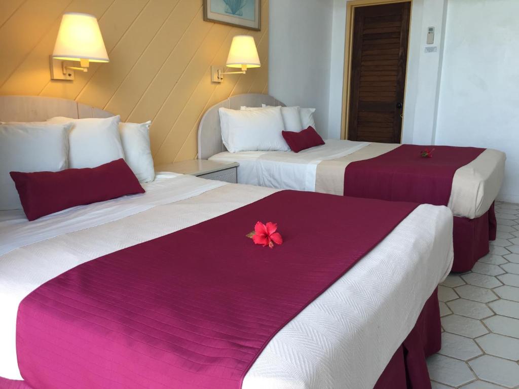 克里斯琴斯特德上岛酒店的两张位于酒店客房的床,上面有粉红色的花
