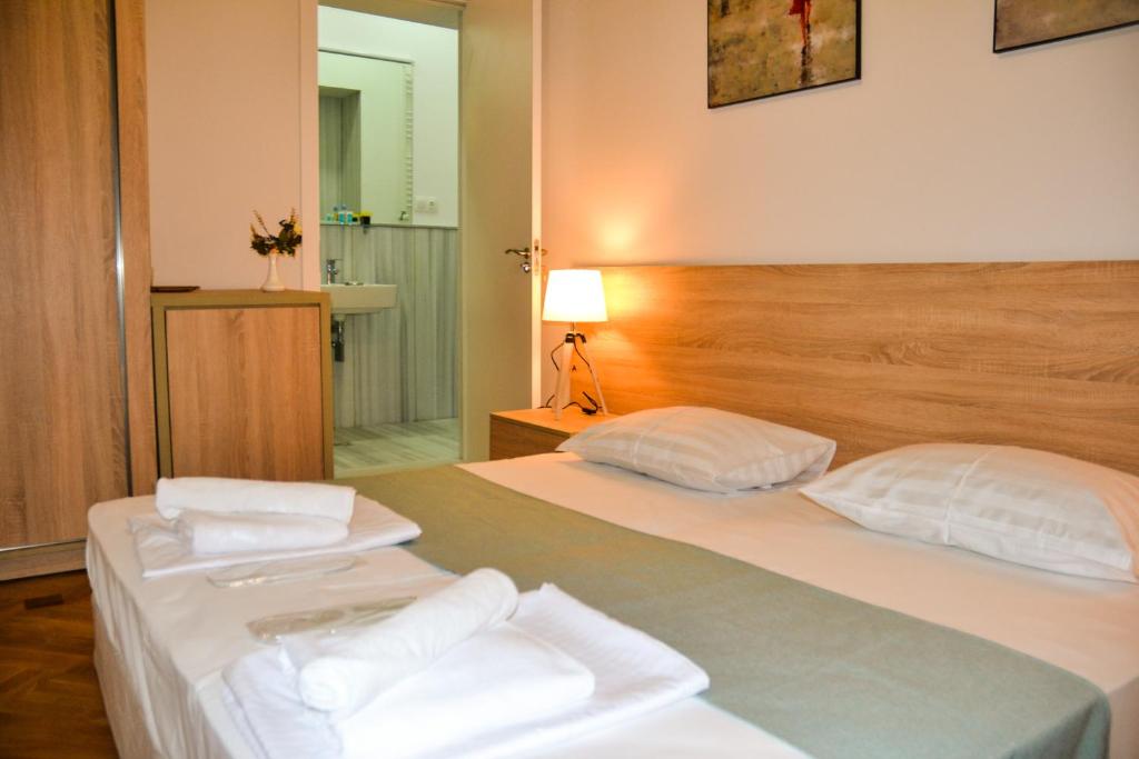 第比利斯Piccolo Casa Bella Hotel的一间卧室配有两张床和白色毛巾。