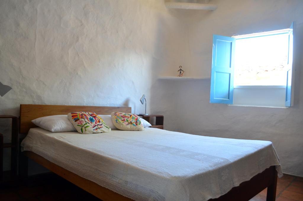 巴里查拉Albahaca Hospedaje Tienda的一间卧室配有一张带蓝色窗户的床