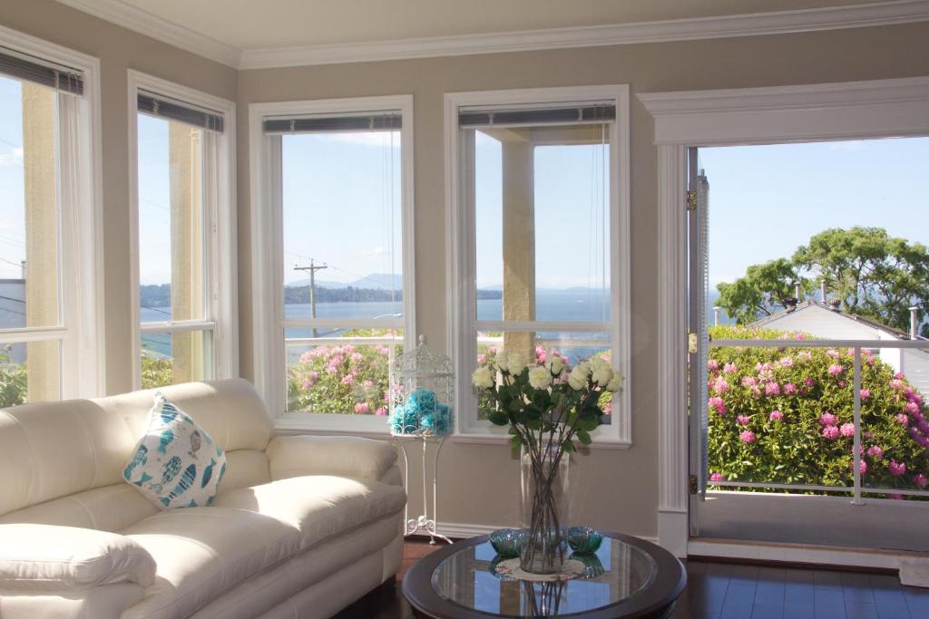 白石Star of the Sea guest house的带沙发的客厅和鲜花窗户