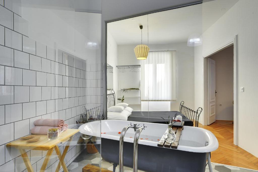 普拉Apartments Forum的一间带浴缸和大镜子的浴室