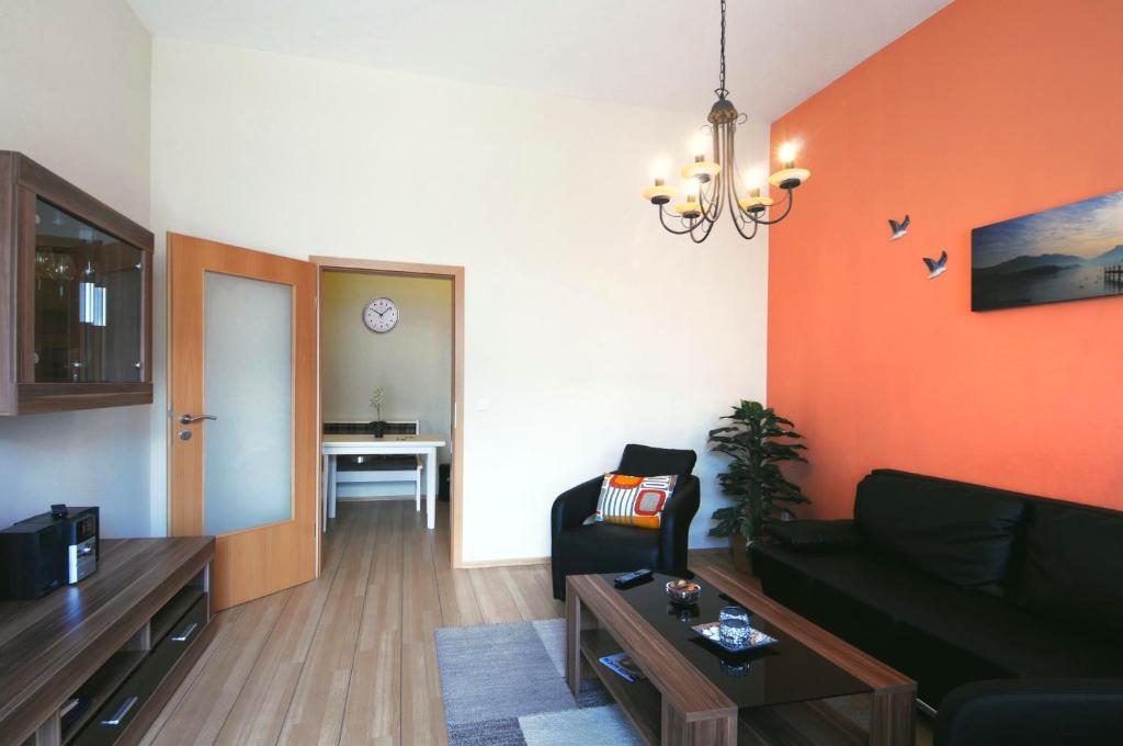 瓦尔内明德Ferienwohnung Warnemünde - L (N)的客厅配有黑色沙发和橙色墙壁